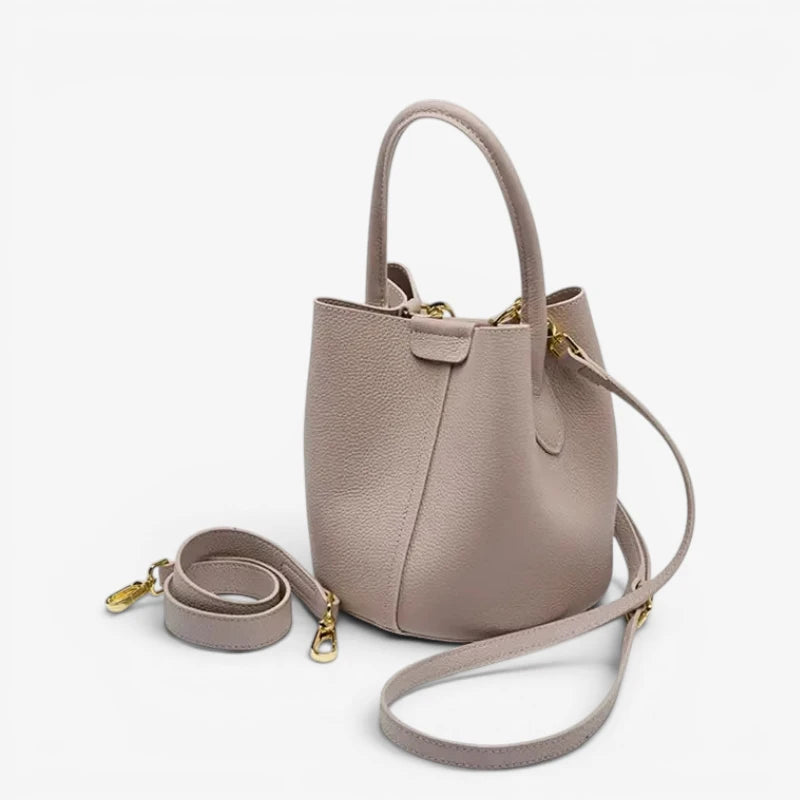 Vue trois quarts du sac seau en cuir de vachette avec poignée et bandoulière